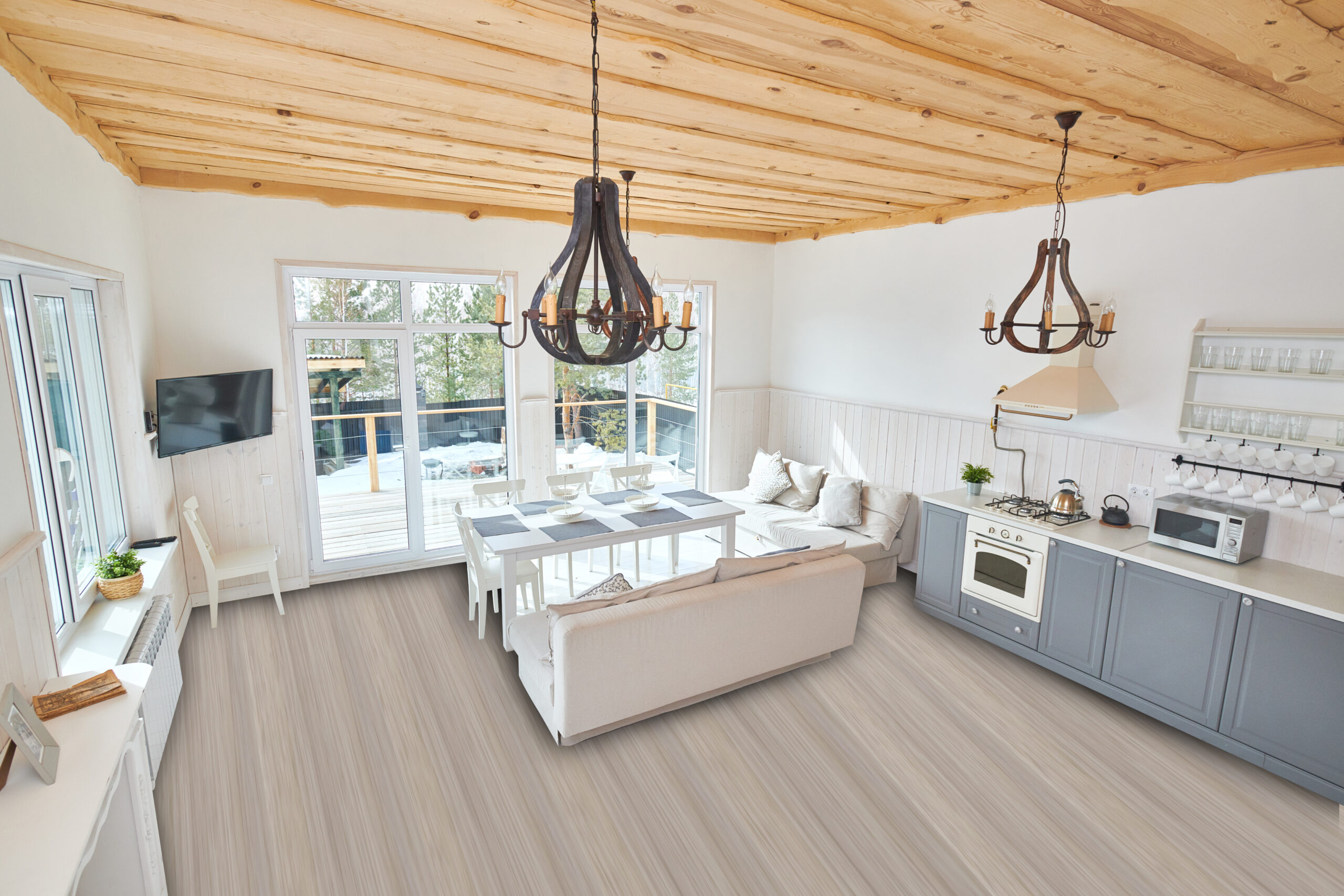 Wide angle of modern open living room interior overlooking floor to ceiling windows with white furniture and grey kitchen counters in minimalistic Scandinavian design by sunlight, copy space, nobody