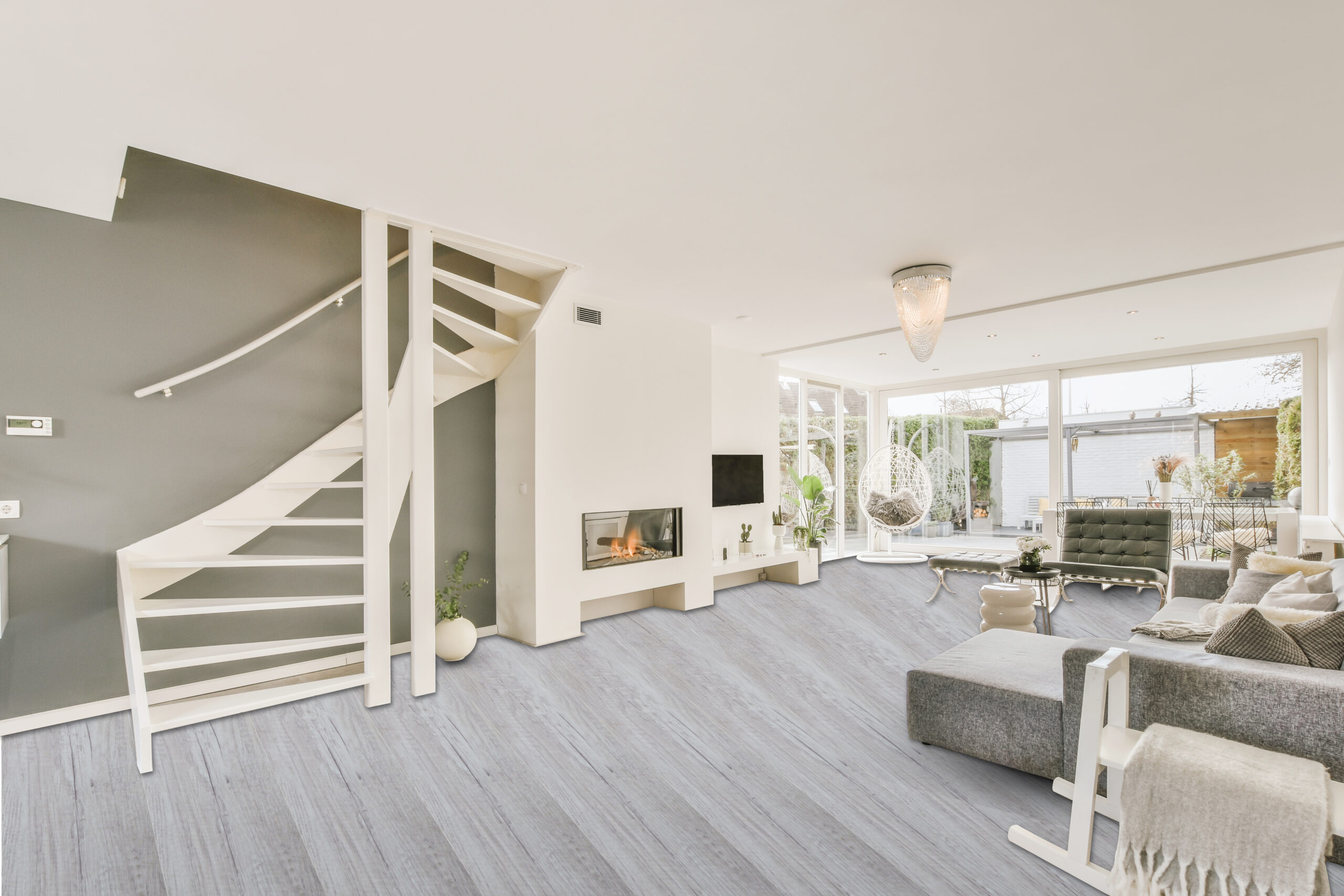 Contemporary minimalist style interior design of light studio apartment with wooden table and chairs in dining zone between open kitchen and living room with white walls and parquet floor
