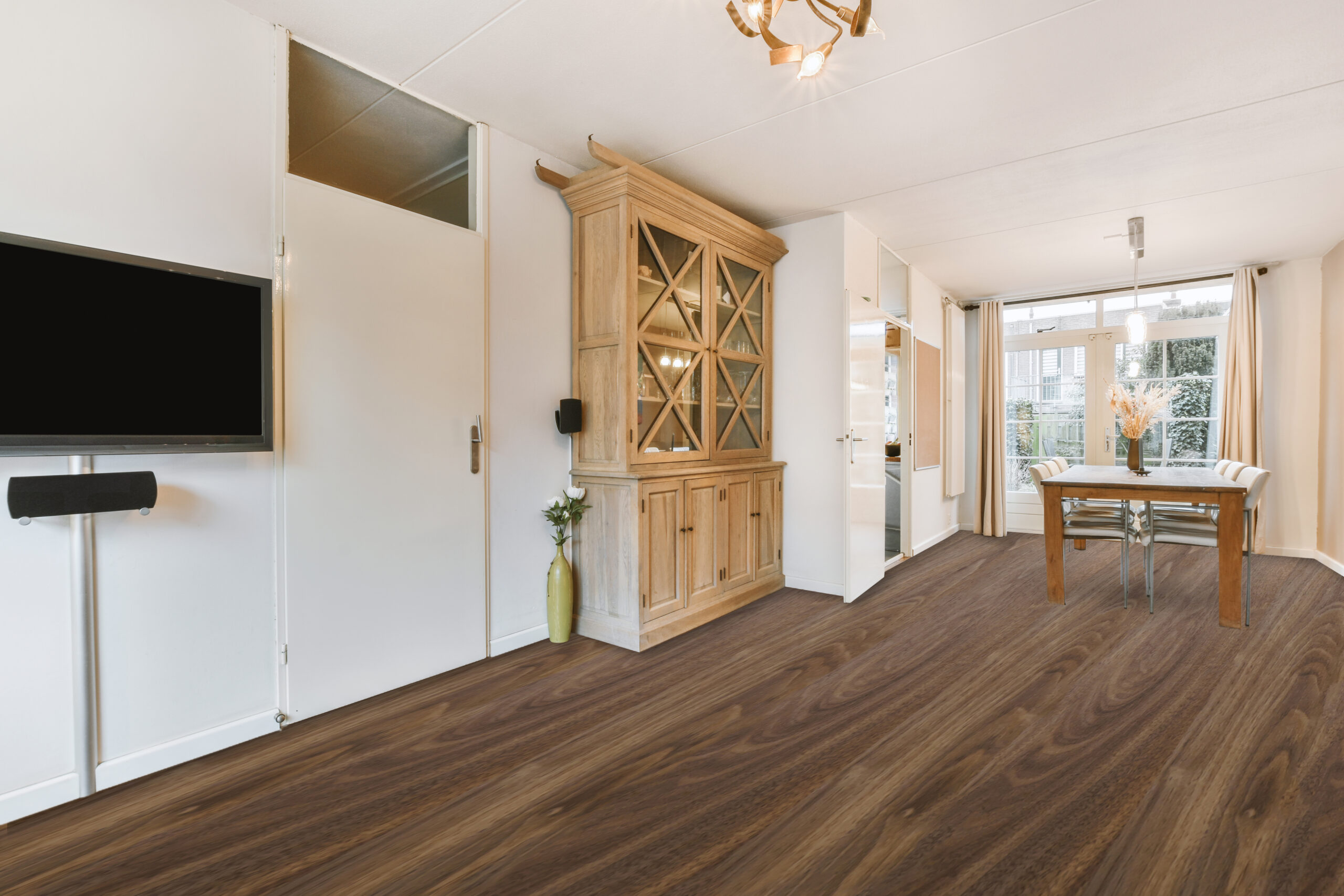 Spacious living room with wooden cabinet, door and dining zone near passage to kitchen with beige walls and parquet