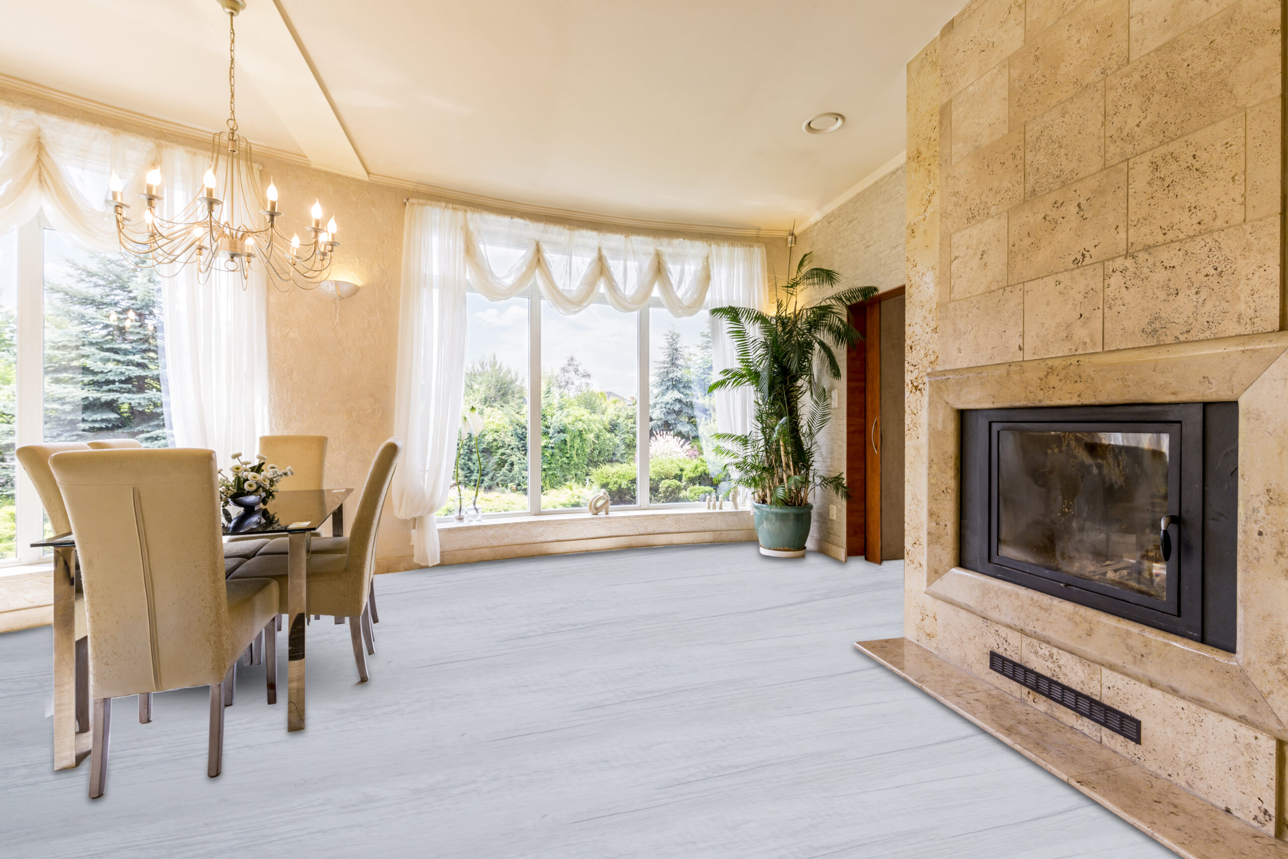 Bright, marble open dining space with table and chairs, chandelier and fireplace